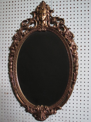 An oval bevelled plate wall mirror contained in a decorative gilt  frame 27"