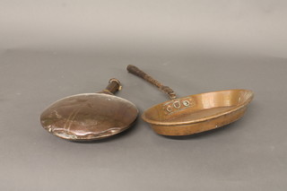 A circular copper warming pan and a 19th Century oval copper saucepan with iron handle