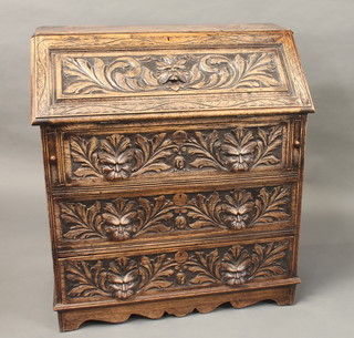 A Victorian carved oak bureau, the fall front revealing a well  fitted interior above 3 long drawers with lion mask decoration  36"