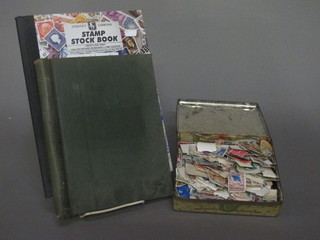 A small tin of stamps, a small green album of stamps and other  stamps