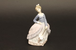 A Lladro figure of a standing lady with parasol 7", base marked 23,