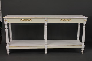 A rectangular white painted 2 tier side table with gilt decoration  raised on turned and reeded supports 73"