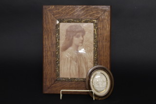 An Art Nouveau monochrome print of a standing girl 9" x 6" contained in an oak frame together with an oval plaster plaque  depicting The Holy Family, 3" oval