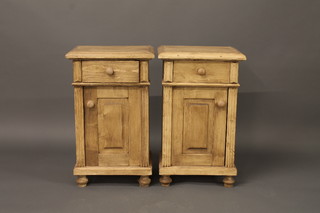 A pair of Continental polished pine bedside cabinets fitted a drawer above a cupboard, raised on bun feet 17"