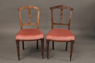 A pair of Victorian carved walnut bar back dining chairs with pierced slat back and upholstered seats, raised on tapering  supports