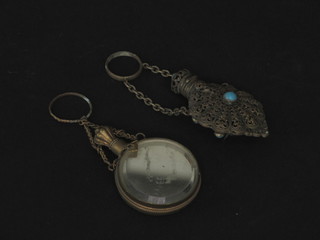 A filigree scent bottle and a circular mirrored scent bottle