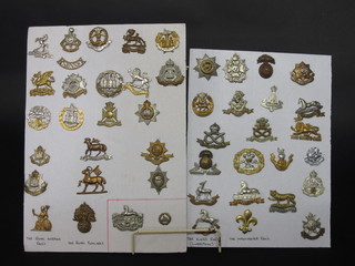 A collection of 26 various cap badges including The Sussex Regt., Middlesex Regt., Royal West Kents, Gloucesters, etc,  mounted on 2 cardboard cards