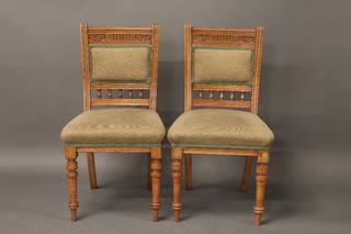 A set of 6 Edwardian bleached oak dining chairs with upholstered seats and backs, raised on turned supports