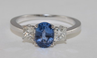 An 18ct white gold dress ring set an oval Princess cut sapphire approx 0.95ct supported by diamonds, approx. 0.47ct