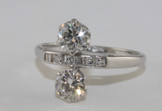 A lady's platinum dress ring set 2 diamonds supported by  baguette cut diamonds  ILLUSTRATED