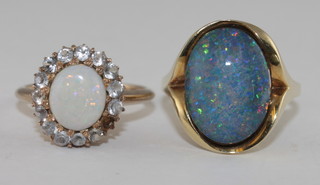A gold dress ring set an opal surrounded by diamonds, 1  diamond missing, and a gold dress ring set an "opal"