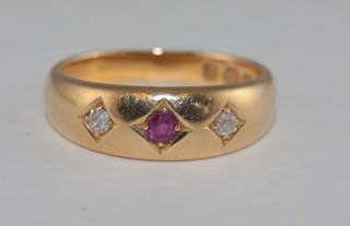 An 18ct gold dress ring set a ruby supported by 2 diamonds