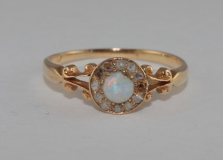 A gold dress ring set an opal surrounded by diamonds