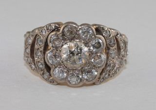 An 18ct gold dress ring set a large circular cut diamond and  numerous diamonds to the shoulders  ILLUSTRATED