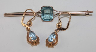 A gold bar brooch set a Topaz? together with a pair of matching earrings