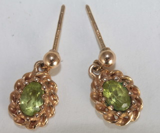 A pair of gilt metal and peridot set earrings