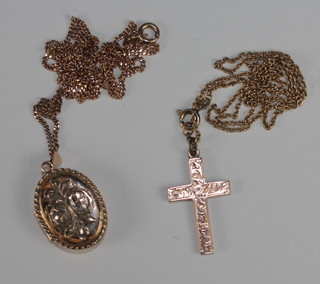 A fine gold chain hung an oval engraved gold locket and a fine  gold chain hung a cross
