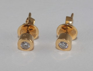A pair of diamond and yellow gold ear studs