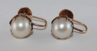A pair of gold ear studs set pearls with screw backs