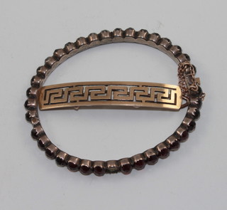 A gold hair clip together with a gilt metal bracelet set red stones