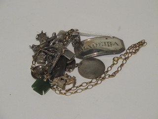 A silver charm bracelet hung numerous charms, a white metal  charm in the form of a dog, a gilt chain and a decanter label