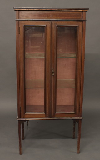 A rectangular Edwardian inlaid mahogany display cabinet, the  shelved interior enclosed by glazed panelled doors, raised on  square supports 23"