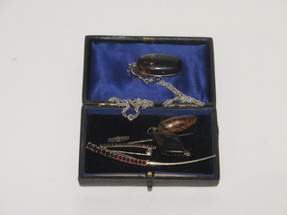 A gilt metal crescent shaped brooch set red stones, a stick pin, 2 hardstone pendants and an oval amber pendant