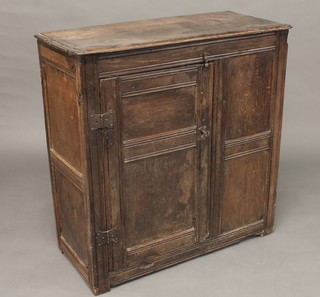 A 17th/18th Century oak cabinet of panelled construction  enclosed by a panelled door 34"