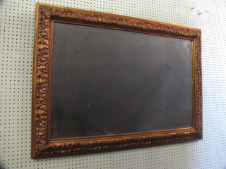 A rectangular bevelled plate wall mirror contained in a decorative  gilt frame 44"