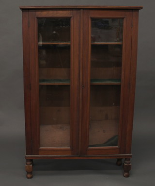 A 19th Century pine bookcase fitted shelves enclosed by glazed panelled doors, raised on turned and block supports 33"