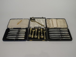 A set of 6 silver handled tea knives, a set of 6 mother of pearl handled tea knives and 12 gold plated tea spoons and a serving  spoon