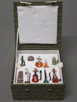 A box containing 9 various Oriental hardstone models of instruments