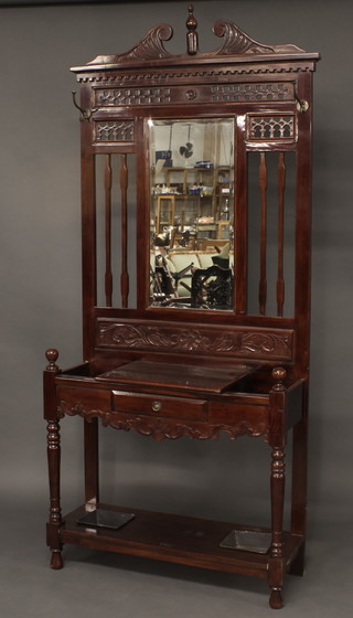 A Victorian style mahogany hall stand with pierced back and bevelled plate mirror to the centre, the base fitted 2 drip trays,  raised on turned supports 39"