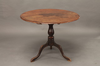 An 18th Century elm snap top tea table, raised a turned column  and tripod support 34"