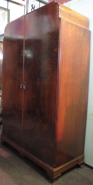 An Art Deco walnut double wardrobe enclosed by panelled  doors, raised on ogee bracket feet 47"