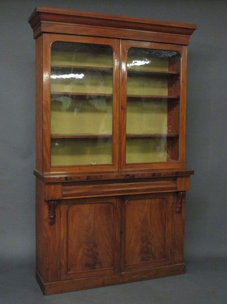 A Victorian mahogany bookcase on cabinet, the upper section  with moulded cornice and shelved interior enclosed by glazed  panelled doors, the base fitted 1 long drawer above a double  cupboard enclosed by panelled doors, raised on a platform base  46"  ILLUSTRATED