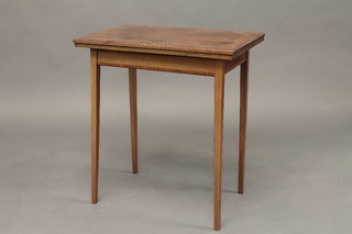 An Edwardian rectangular inlaid mahogany card table, raised on  square tapering supports 24"