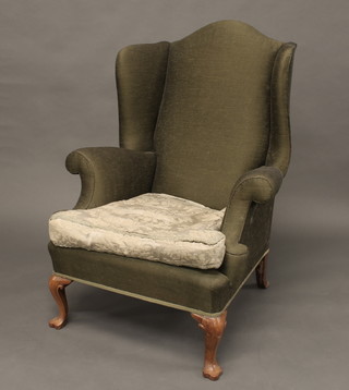 A Queen Anne style walnut winged armchair upholstered in  green material, raised on cabriole supports
