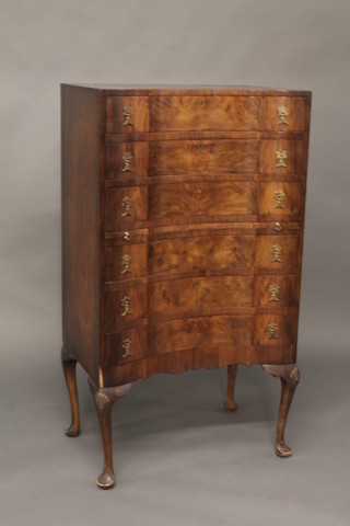 A Georgian style walnut serpentine fronted chest of 6 long  drawers with brass petal handles, raised on cabriole supports 25"