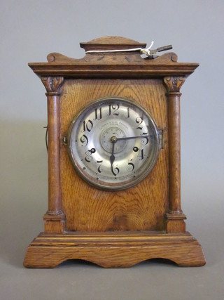 An Art Nouveau 8 day striking bracket automatic repeating alarm  clock by Fattorin & Sons of Bradford, contained in an oak case