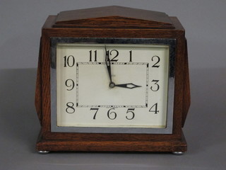 An Art Deco Smiths electric mantel clock with painted dial and Arabic numerals contained in an oak case