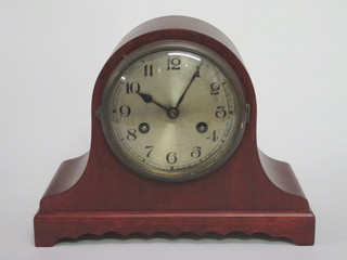A striking mantel clock with silvered dial and Arabic numerals contained in a mahogany Admiral's hat shaped case