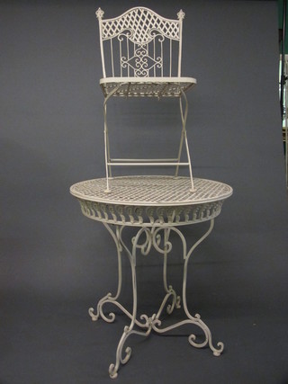 A circular pierced metal folding garden table together with 4  folding chairs