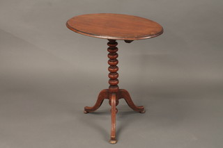 An oval mahogany snap top wine table raised on bobbin turned  support with tripod base 25"