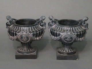 A pair of plastic twin handled planters decorated cherubs, raised  on square feet 12"