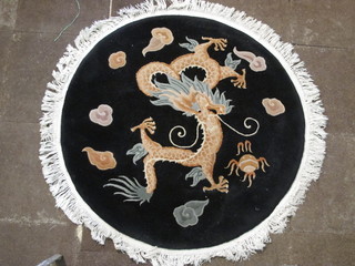 A black ground circular Chinese rug decorated a dragon 49"