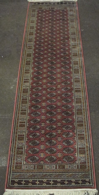 A peach ground Bokhara style runner with numerous octagons to the centre 110" x 30"