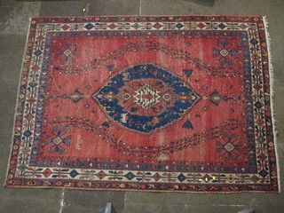 A red ground Afghan rug with central medallion, signed 90" x  65"