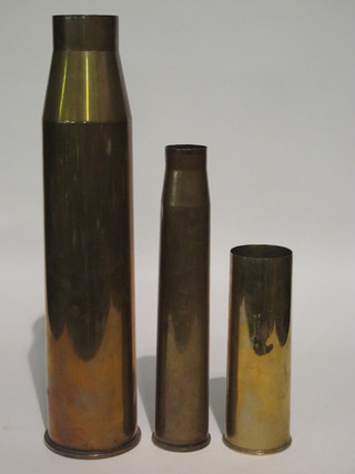 A large brass shell case, a 25lb shell case and a 6lb shell case