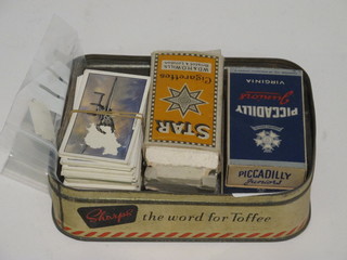 A collection of cigarette cards in a metal box